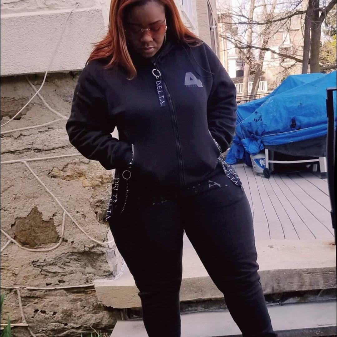 D.E.L.T.A. customer wearing the signature 4 zip-up hoodie and joggers set